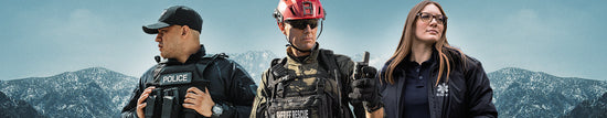 Three emergency responders—police officer, firefighter, and EMT—stand outdoors in uniform with mountains in the background.
