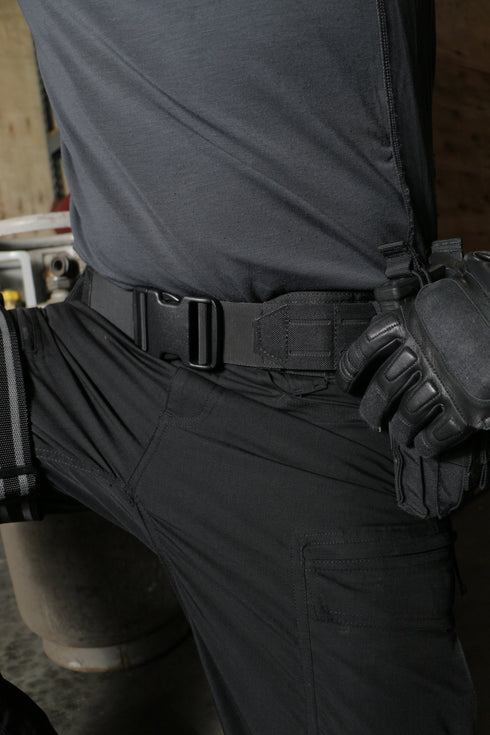 A person shown from torso to thigh wears tactical gear—a grey shirt with black pants, gloves, holster, and the Condor LCS Gun Belt—ready for any first responder scenario.