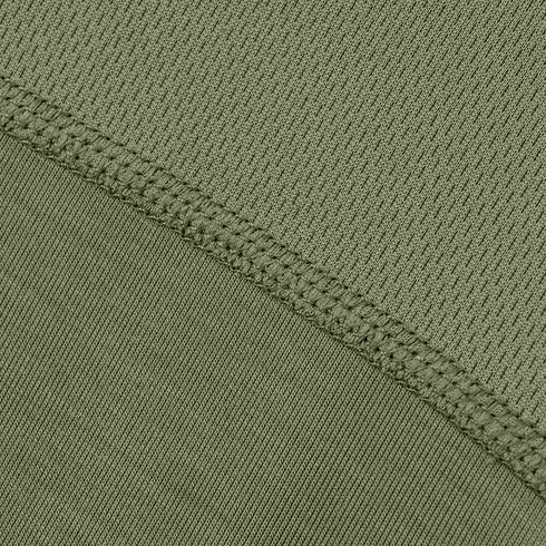 Close-up of the Condor Trident Short Sleeve Battle Tops green tactical fabric, featuring a diagonal seam with visible stitching that separates two areas with subtly different textures.