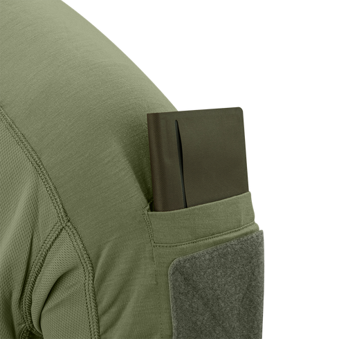 A green notebook is partially tucked into the sleeve pocket of the Condor Trident Short Sleeve Battle Top in olive green.