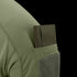 A green notebook is partially tucked into the sleeve pocket of the Condor Trident Short Sleeve Battle Top in olive green.