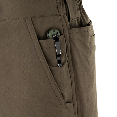 A close-up of a green folding knife, a must-have EDC tool, clipped to the front pocket of Condor Maverick Shorts.