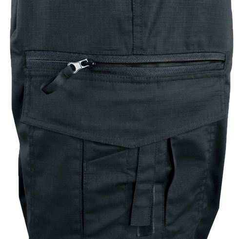 Close-up of a black fabric pocket on the Condor Women's Protector EMS Pants, featuring a horizontal zipper and a flap with a strap below it.