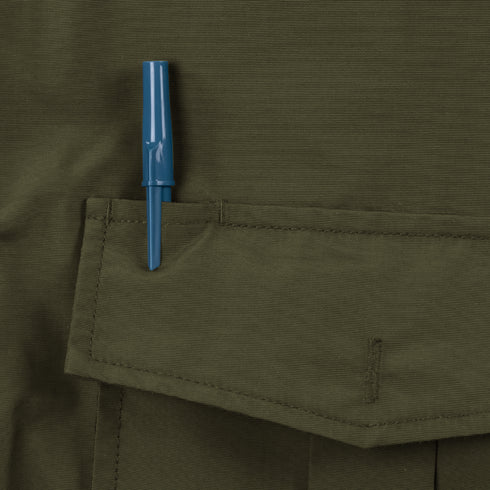 A blue pen is clipped to the top pocket flap of a Condor Guardian Duty Jacket in olive green.