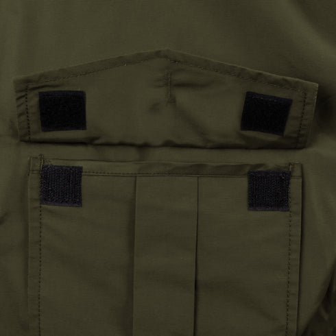 Close-up of an olive green pocket on the Condor Guardian Duty Jacket | SALE, featuring a flap secured by two black hook-and-loop fasteners, commonly used in military or law enforcement gear.