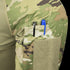 A close-up of the Condor Long Sleeve Combat Shirt Gen II - Scorpion OCP shows a sleeve with a zippered pocket and two pen slots, one holding a silver pen and the other a blue pen.