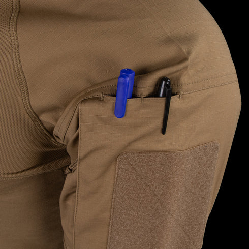 Close-up of the Condor Short Sleeve Combat Shirt Gen II’s brown, lightweight sleeve pocket holding a blue and a black pen, with a velcro patch below the pocket opening.