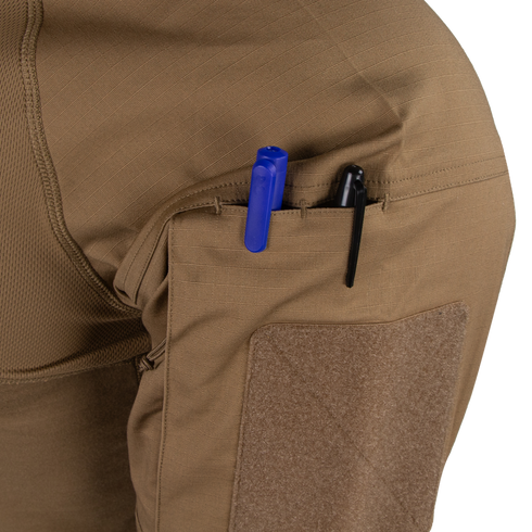 Close-up of the Condor Short Sleeve Combat Shirt Gen II’s brown, lightweight sleeve pocket holding a blue and a black pen, with a velcro patch below the pocket opening.