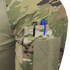 A close-up of the Condor Short Sleeve Combat Shirt Gen II in Scorpion OCP shows a camouflage sleeve featuring a zippered pocket with two pens, one black and one blue, inserted into dedicated pen slots.
