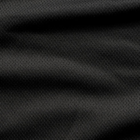 Close-up of the Condor Trident Sun Shirt’s black textured fabric, featuring subtle horizontal folds and a fine, slightly raised pattern.
