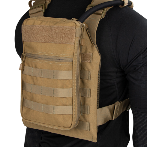 Person wearing the Condor Tidepool Hydration Carrier—a tan vest with zippered front pouch and MOLLE webbing—over a black long-sleeve shirt; perfect for bushcraft or range use.