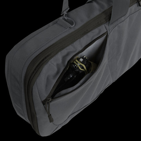 A Condor 36 Javelin Rifle Case in gray features a zippered outer pocket, partially open to reveal a black camera with a green strap tucked inside.
