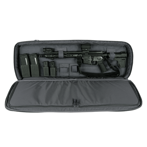 A black rifle with scope and magazines is stored in the Condor 36" Javelin Rifle Case, a padded gray carrying case with accessory compartments.