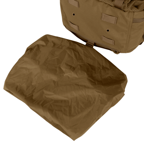 A folded brown tarp is placed next to a Condor Orion Assault Backpack 50L, a tan bushcraft or EDC pack with straps and loops, resting on a light surface.
