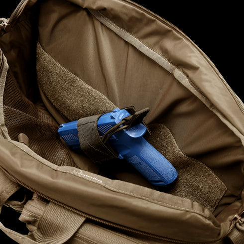 A blue training pistol secured inside the Condor Elite Metropolis Briefcase by Condor, featuring a brown tactical design with a Velcro strap—ideal for military or first responder training scenarios.