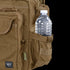 A plastic water bottle sits in the side mesh pocket of a tan Condor Elite Metropolis Briefcase, a versatile bag by Condor featuring multiple zippered compartments, popular with military and first responders.