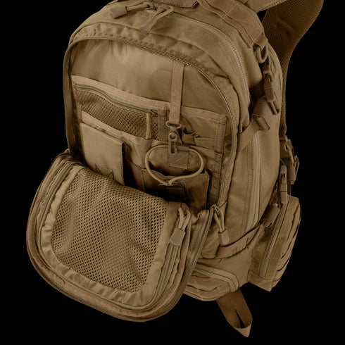 The Condor Elite Titan Assault Backpack 40L by Condor, shown in tan with multiple compartments and zippers, has its front pocket unzipped to reveal mesh and fabric organizers—ideal for bushcraft or first responders.