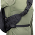A close-up of a person wearing the Condor Elite Sector Sling Bag 18L by Condor, featuring black tactical straps with clips and padding, over an olive green long-sleeve shirt.