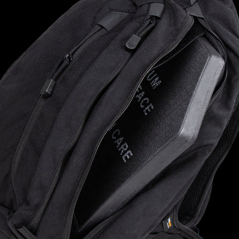 A Condor Elite Sector Sling Bag 18L in black is shown with a partially open zipper, revealing a protective ballistic plate inside.
