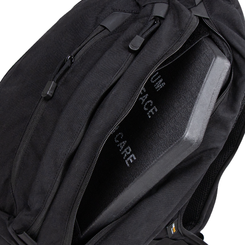 A Condor Elite Sector Sling Bag 18L in black is shown with a partially open zipper, revealing a protective ballistic plate inside.