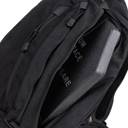 A Condor Elite Sector Sling Bag 18L in black is shown with a partially open zipper, revealing a protective ballistic plate inside.