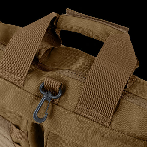 Close-up of the Condor Aviator Bag 15L in brown tactical fabric with reinforced handles, a zipper, and a black plastic clip on a loop—perfect for military or first responder use.