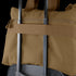 A Condor Aviator Bag 15L in brown is secured on top of a rolling suitcase using the suitcase handle.