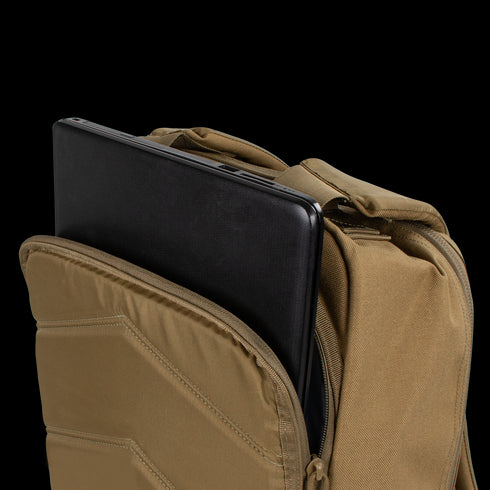 A tan Condor Prime Pack 21L tactical backpack with a partially open zipper shows a black laptop inside the main compartment.