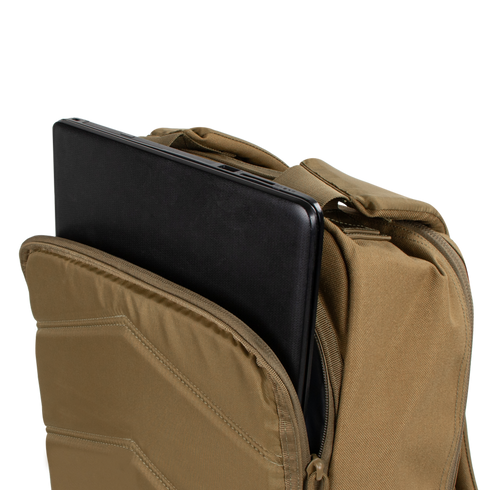 A black laptop is partially inserted into the padded compartment of the tan Condor Prime Pack 21L backpack.
