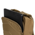 A black laptop is partially inserted into the padded compartment of the tan Condor Prime Pack 21L backpack.
