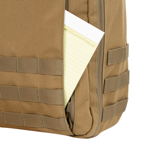 Close-up of the Condor Prime Pack 21L tan backpack with a yellow legal pad partially visible in its outer pocket.