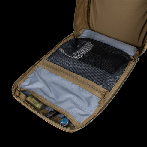 The Condor Prime Pack 21L in tan is shown open, revealing a mesh zippered pocket with coiled cables and another compartment holding small gear.
