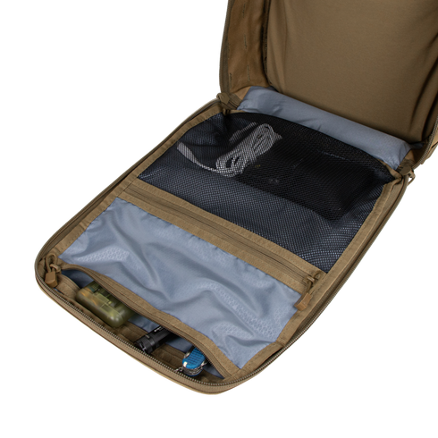 The Condor Prime Pack 21L in tan is open to reveal well-organized compartments, featuring a mesh zippered pocket, a smaller fabric pocket, and various small items neatly stored in each section.