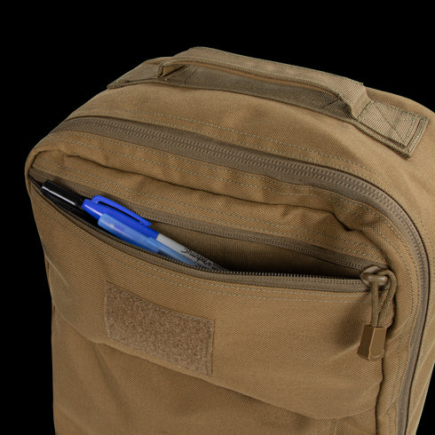 The Condor Prime Pack 21L is a tan tactical backpack with a partially open front zippered pocket, revealing black and blue pens and a marker—perfect for first responders on the move.