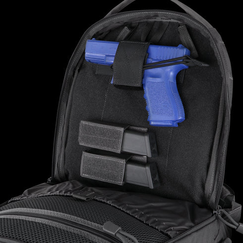A blue training pistol and two black magazines are secured inside the back compartment of a Condor Elite Fail Safe Urban Backpack Gen II 18L by Condor.