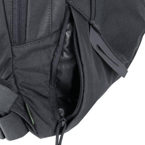 Close-up of the Condor Elite Fail Safe Urban Backpack Gen II 18L by Condor, featuring a black finish, partially open zippered pocket revealing fabric lining inside, and a plastic buckle on the strap.