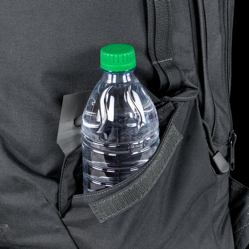 A clear plastic water bottle with a green cap sits in the side pocket of the Condor Elite Fail Safe Urban Backpack Gen II 18L by Condor, ready for a shooting range session or an outdoor bushcraft adventure.
