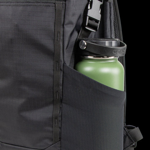 Close-up of a Condor Aero Roll-Top Backpack 25L in black, featuring military-inspired design, with a green reusable water bottle in the side mesh pocket.