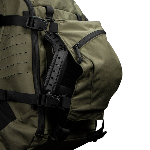 Close-up of the Condor Nomad Backpack 25L in green, showing its zippered side pocket partially open with the handle of a black tool or equipment visible inside.