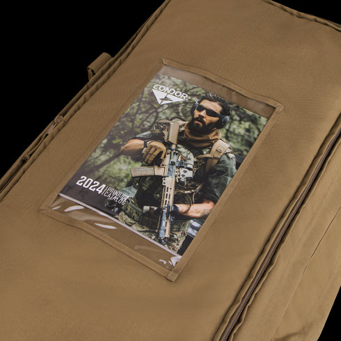 A tan Condor Haul 37 Rolling Duffle with a clear pocket holds a 2024 Condor catalog showing a man in military gear holding a rifle.
