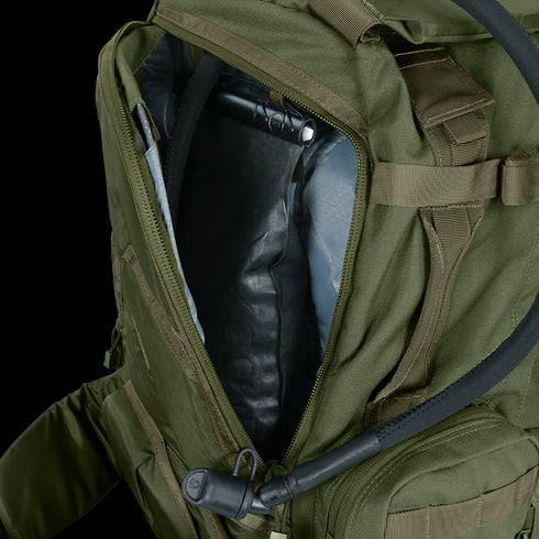 A Condor 3-Day Assault Backpack 50L in olive green is unzipped, revealing a hydration bladder inside with its drinking tube extending outward.