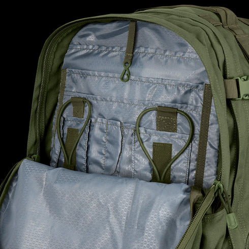 The Condor 3-Day Assault Backpack 50L opens to reveal a gray inner compartment with multiple pockets, elastic loops, and a zippered mesh section for organized storage.