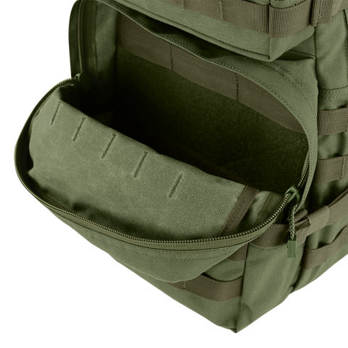 A close-up of an open front pocket on the Condor Medium Assault Backpack 30L in olive green, showing its interior compartment.