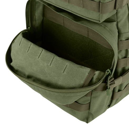 A close-up of an open front pocket on the Condor Medium Assault Backpack 30L in olive green, showing its interior compartment.