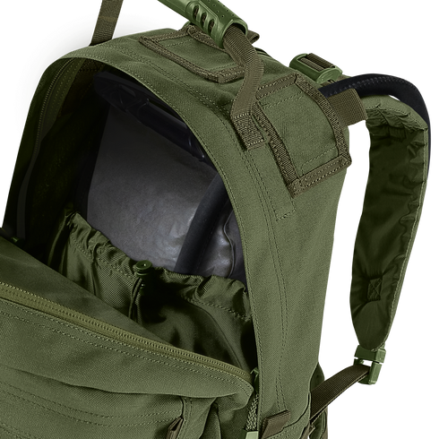 A close-up of the Condor Medium Assault Backpack 30L in olive green shows its top compartment unzipped, revealing an internal hydration bladder.