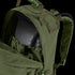A close-up of the Condor Medium Assault Backpack 30L in olive green shows its top compartment unzipped, revealing an internal hydration bladder.