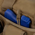 A blue training gun and magazine are placed in the front pocket of the Condor Tactical Response Bag 8L, a brown bag with multiple compartments and straps, designed for tactical use.