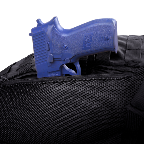A blue training handgun is partially tucked into the zippered pocket of the Condor Ambidextrous Sling 27L, a black tactical bag made with mesh material.