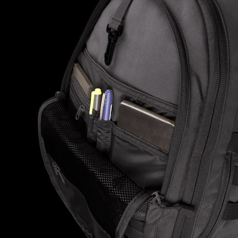 The Condor Ambidextrous Sling 27L, shown in gray with its front pocket open and organized compartments holding two notebooks, a yellow highlighter, a purple pen, and a black pen—perfect for first responder essentials.