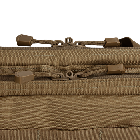 Close-up of two brown zipper pulls on the Condor 36" Double Rifle Case, showing tan fabric, visible stitching, and textured material.